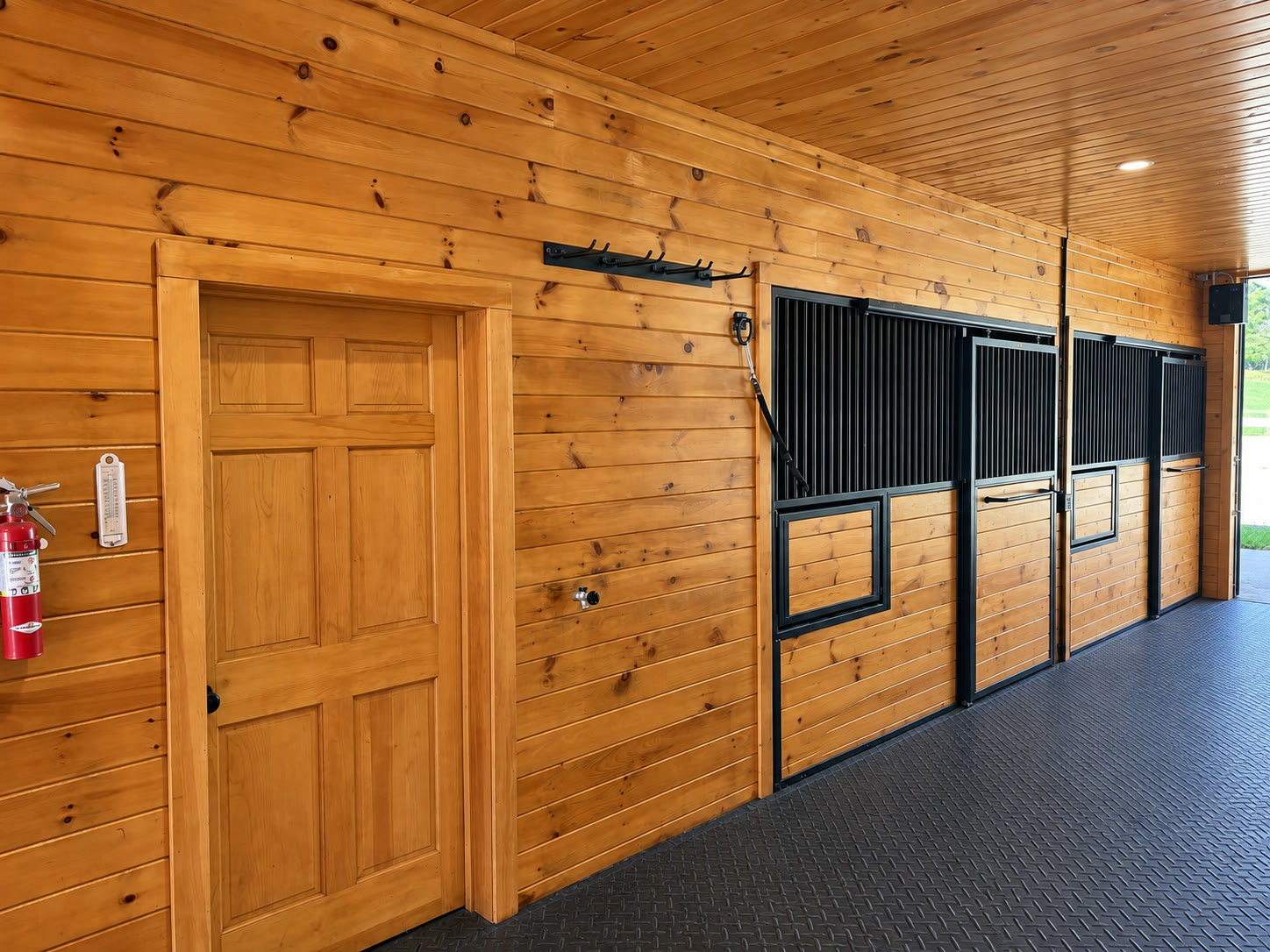 Stained wood hallway with door, coat hooks, and fire extinguisher