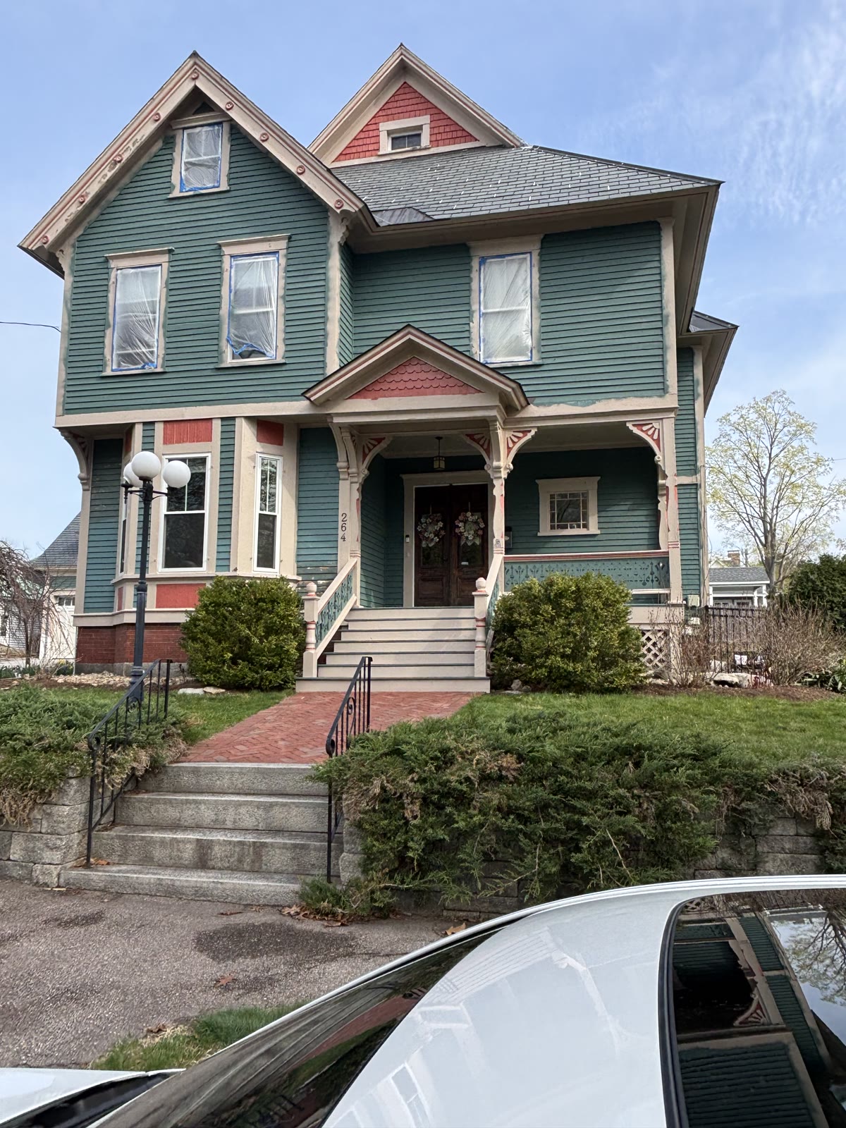Finished Victorian home exterior with teal siding and coral trim
