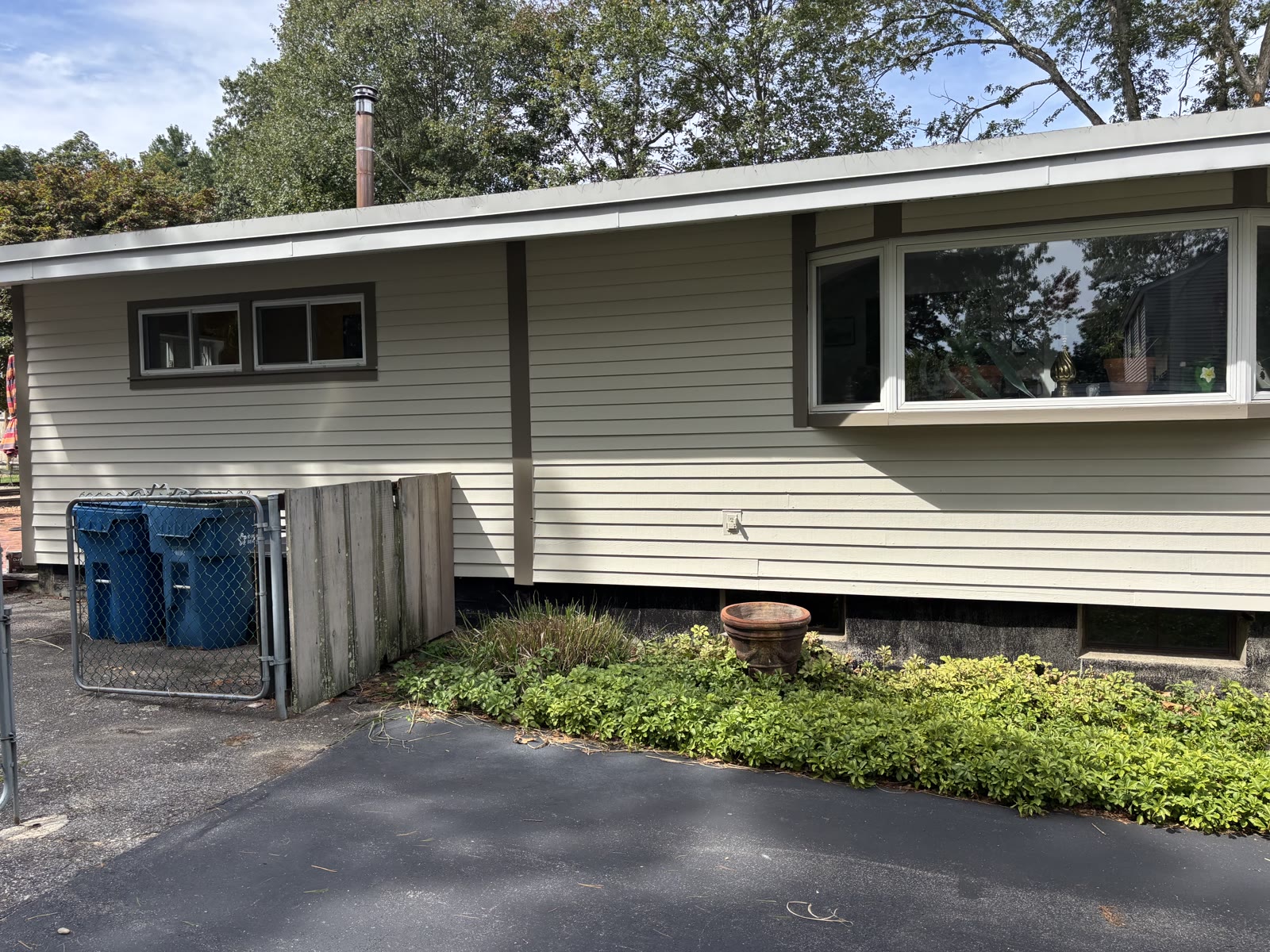 Finished ranch home exterior with cream siding and brown trim
