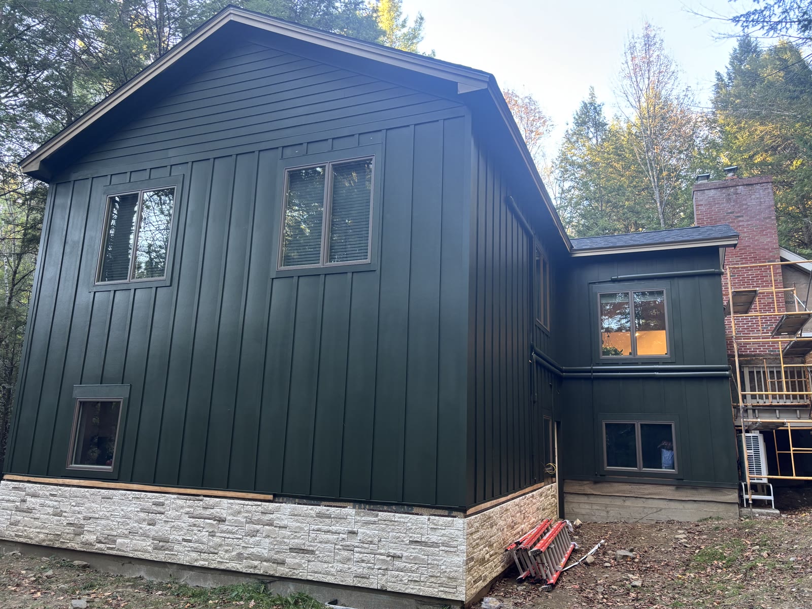 Finished dark green exterior with stone veneer base