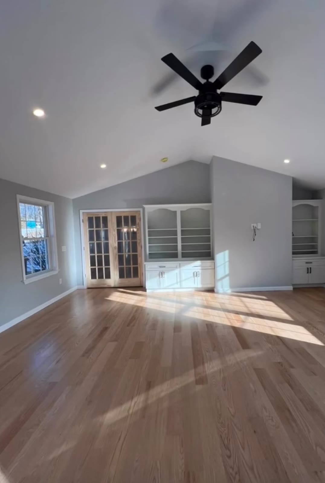 Finished vaulted living room with white built-ins