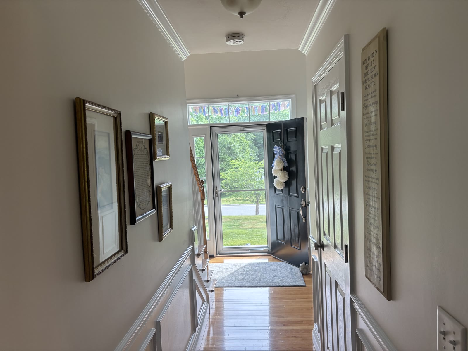 Finished entry hallway with gallery wall and black front door
